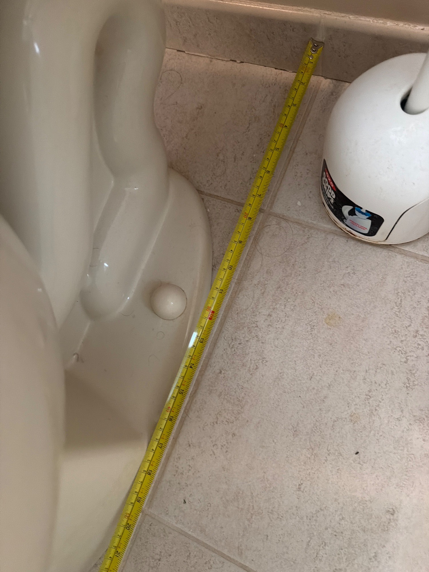 Tape in place: Finished wall behind the toilet, to the center of the bolts at its base
